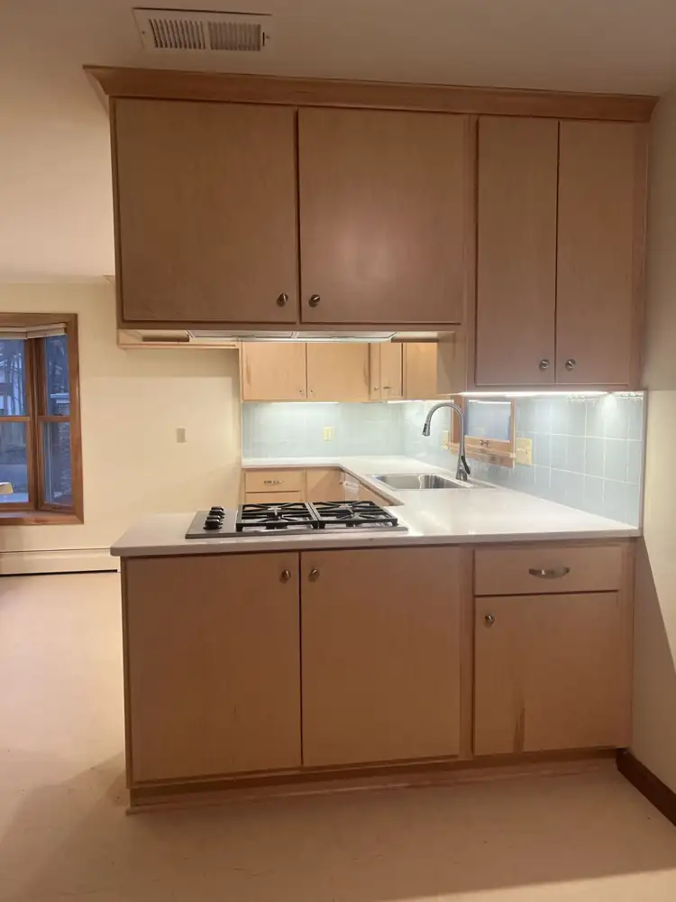 Kitchen peninsula with gas cooktop, maple cabinets and light blue glass tile, Northeast Ohio