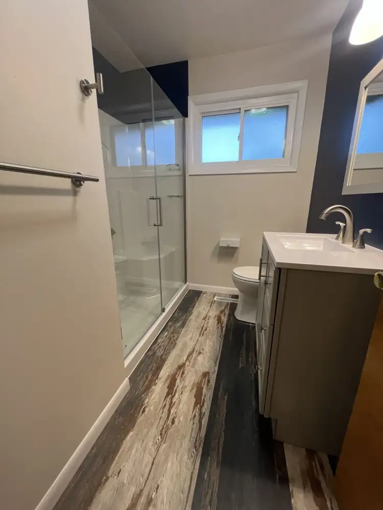 Bathroom with new walk-in shower, frameless glass door, gray vanity and rustic plank floor, Northeast Ohio