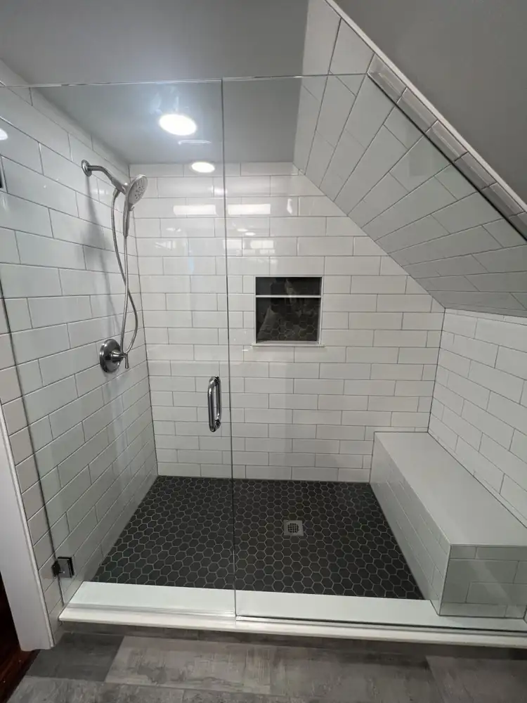 Custom-cut glass shower enclosure for a sloped ceiling with subway tile and bench, Northeast Ohio