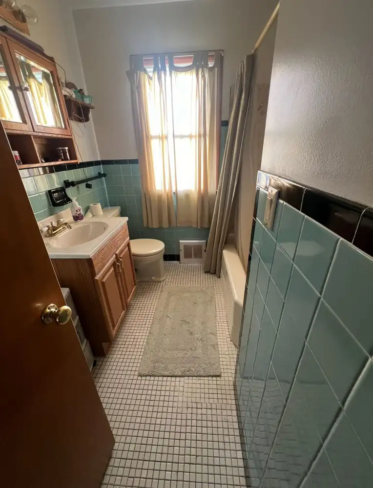 Retro bathroom with teal wall tile, small white floor tile and tub with curtain before remodel, Northeast Ohio