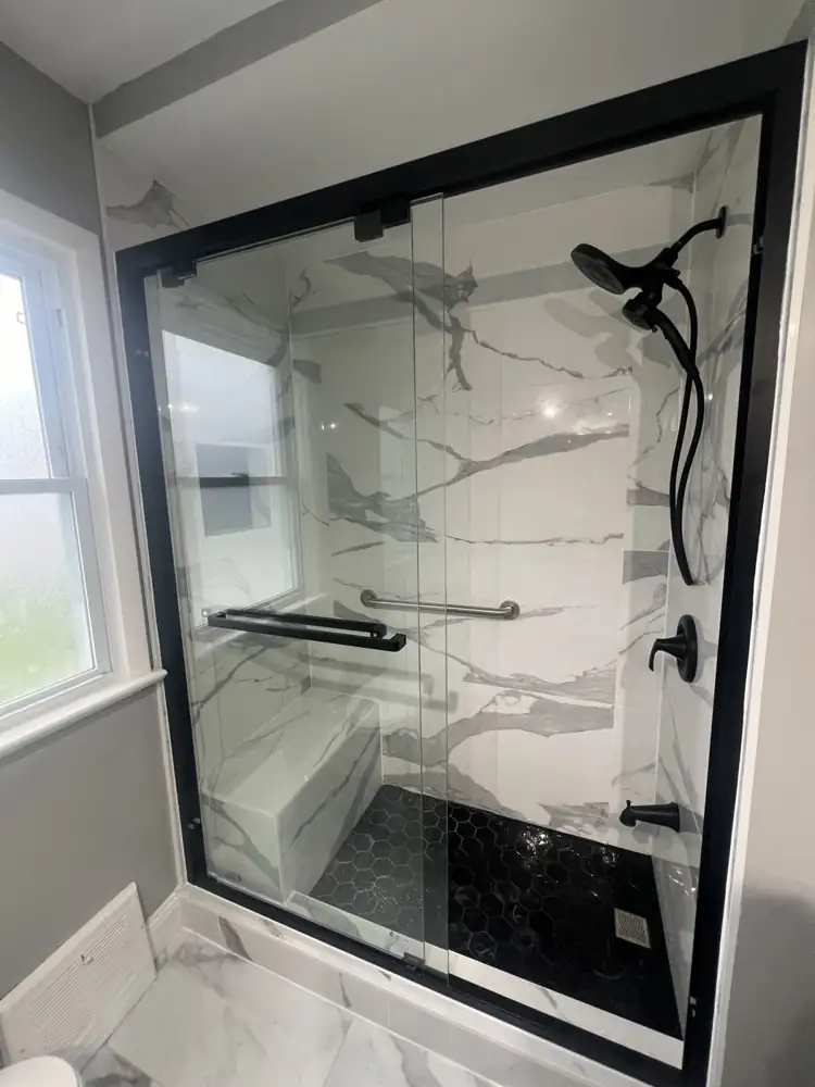 Walk-in shower with marble-look walls, tiled bench, grab bar and matte black fixtures, Northeast Ohio