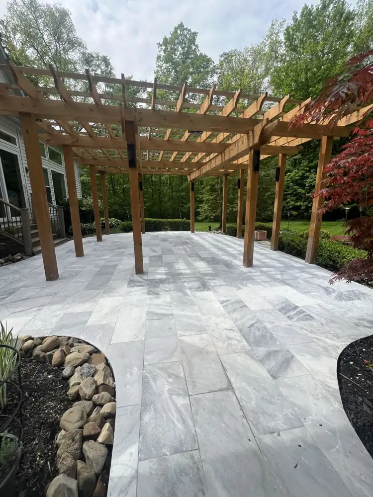 Natural gray marble patio tiles laid under a large cedar pergola, Northeast Ohio