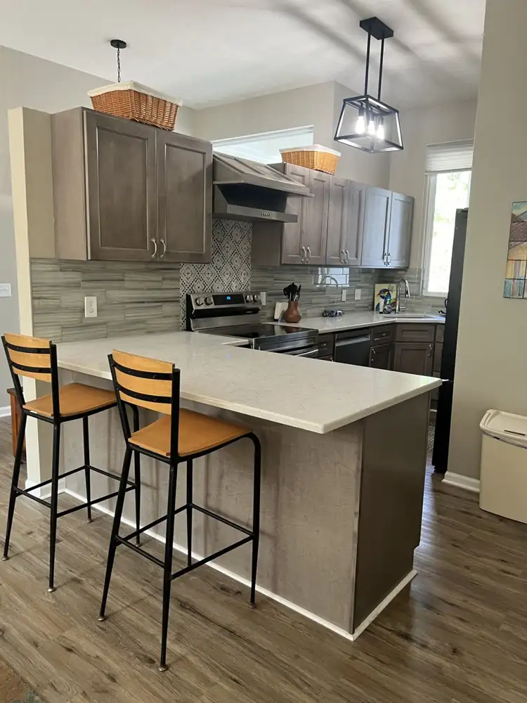 U-shaped gray kitchen with quartz counters, breakfast bar seating and luxury vinyl plank floor, Northeast Ohio