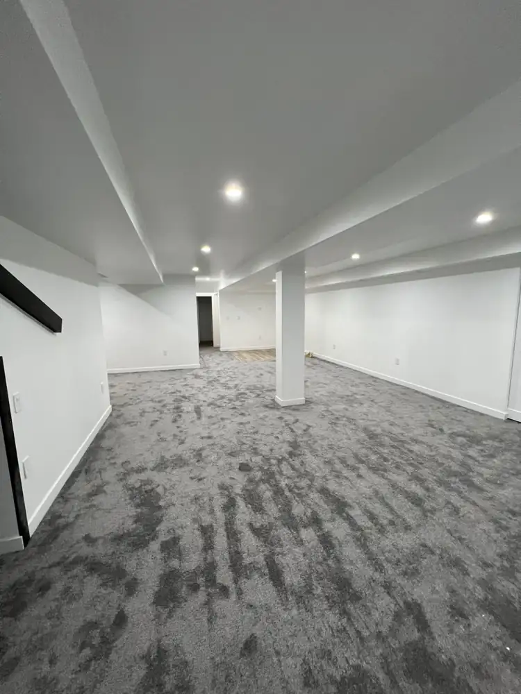 Finished basement with white walls, wrapped soffits, recessed lighting and gray carpet, Northeast Ohio