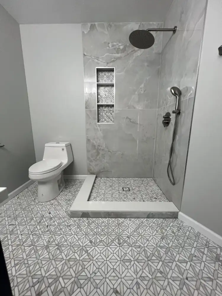 Open shower with onyx-look large-format porcelain, triple niche and quartz curb, Northeast Ohio