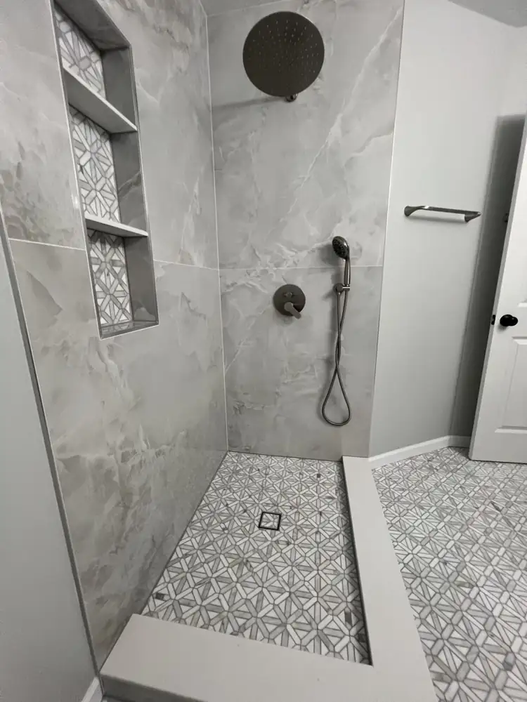 Brushed nickel rain shower and handheld over a marble mosaic shower floor, Northeast Ohio