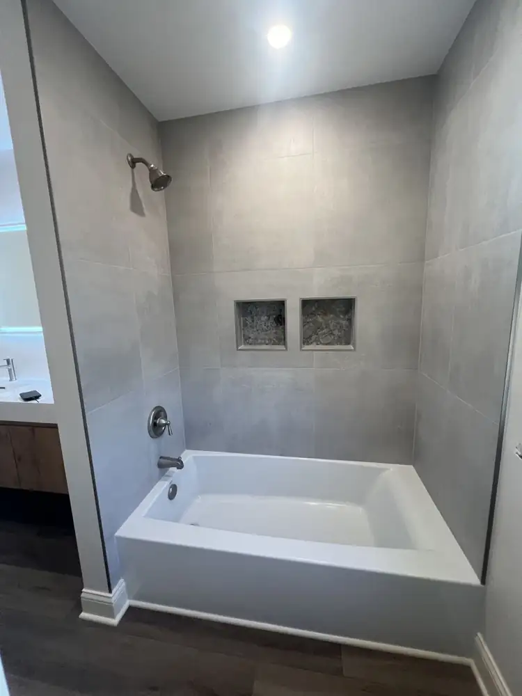 Tub with large gray porcelain surround and two stone mosaic niches, Northeast Ohio