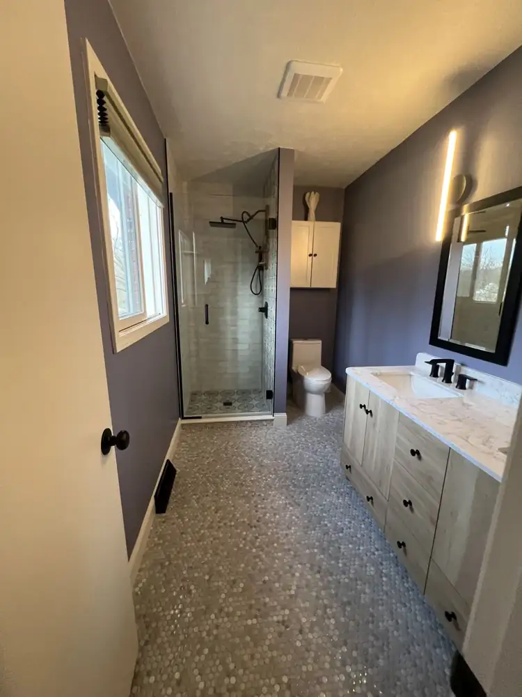 Bathroom with marble penny tile floor, light oak vanity with quartz top, glass shower and matte black fixtures, Northeast Ohio