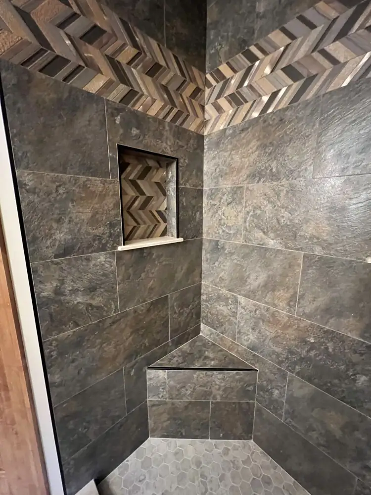 Tiled corner bench and niche with chevron mosaic in a slate-look porcelain shower, Northeast Ohio
