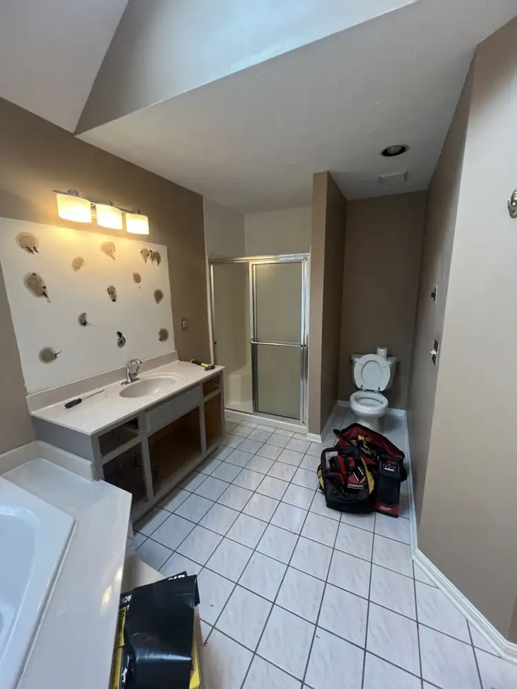 Primary bathroom with framed shower stall, cultured-marble vanity and white tile floor before remodel, Northeast Ohio