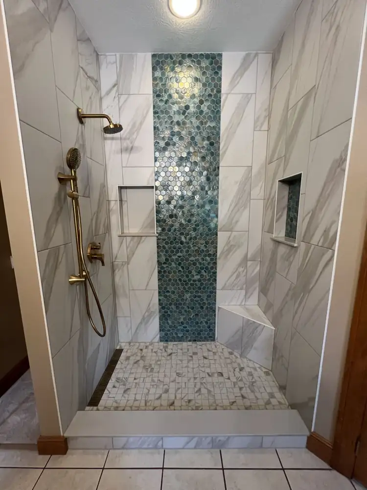 Blue iridescent glass hex mosaic accent wall with marble-look porcelain, niches and linear drain, Northeast Ohio
