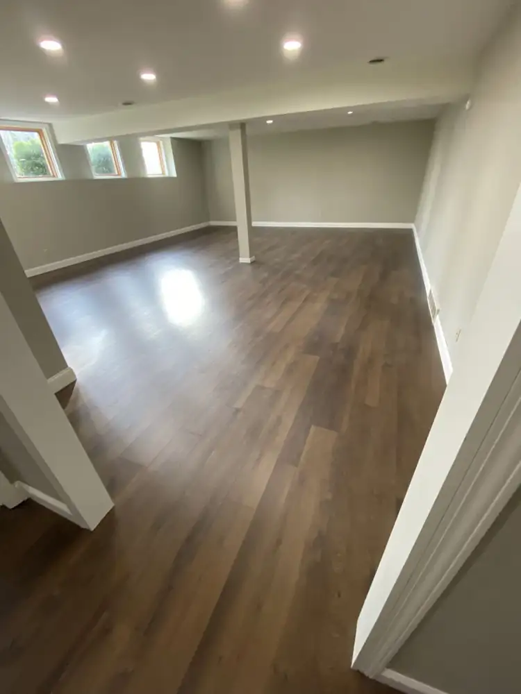 Open basement family room with dark oak-look luxury vinyl plank floor and white trim, Northeast Ohio