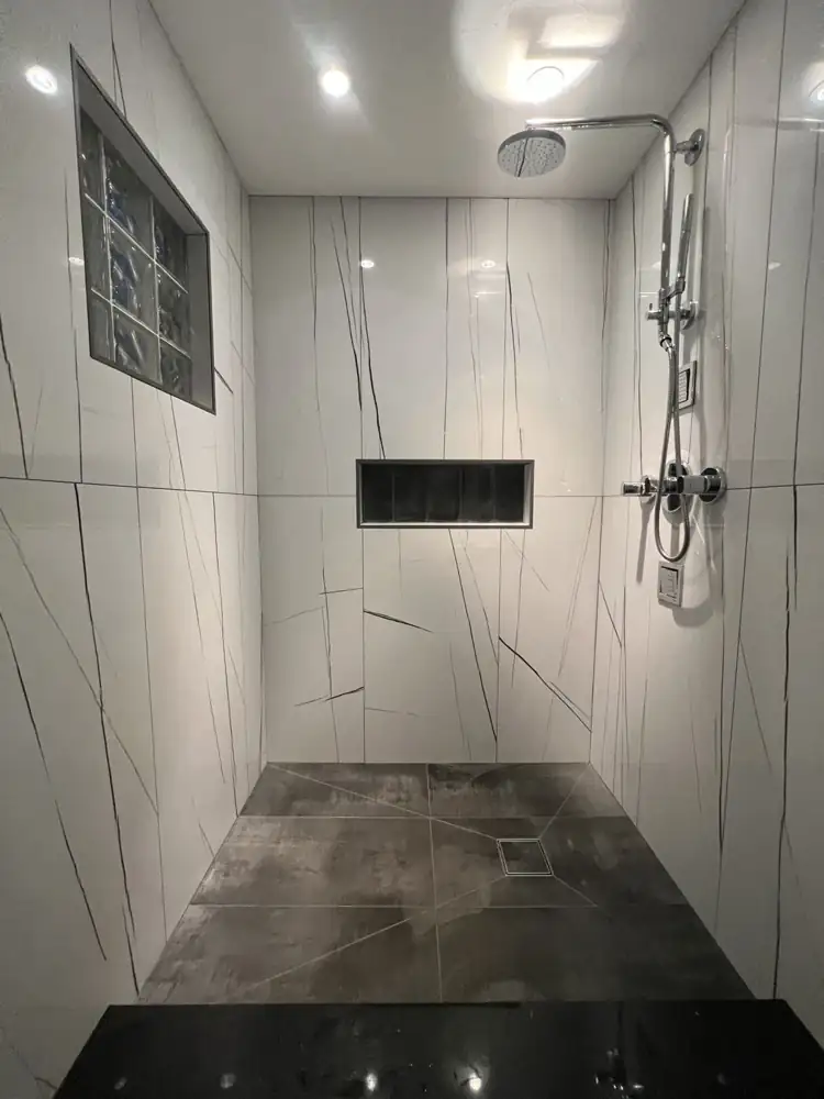 Walk-in shower with white large-format porcelain, glass block window, recessed niche and rain shower, Northeast Ohio