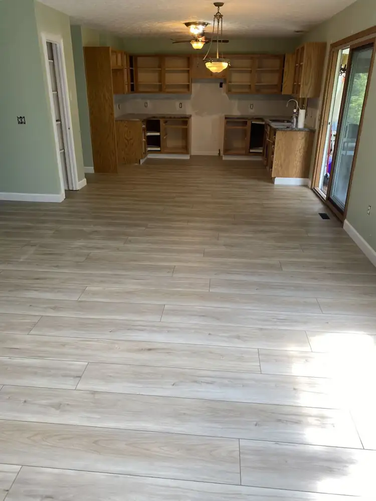 Kitchen and dining area with new light oak-look luxury vinyl plank flooring and white baseboards, Northeast Ohio