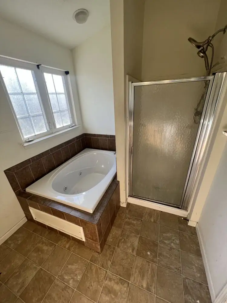 Dated bathroom with tiled jetted tub and fiberglass shower stall before remodel, Northeast Ohio