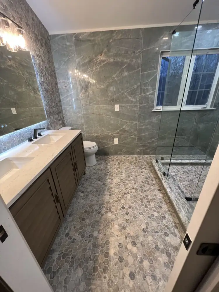 Bathroom with green marble-look porcelain walls, hex mosaic floor and double vanity with quartz top, Northeast Ohio