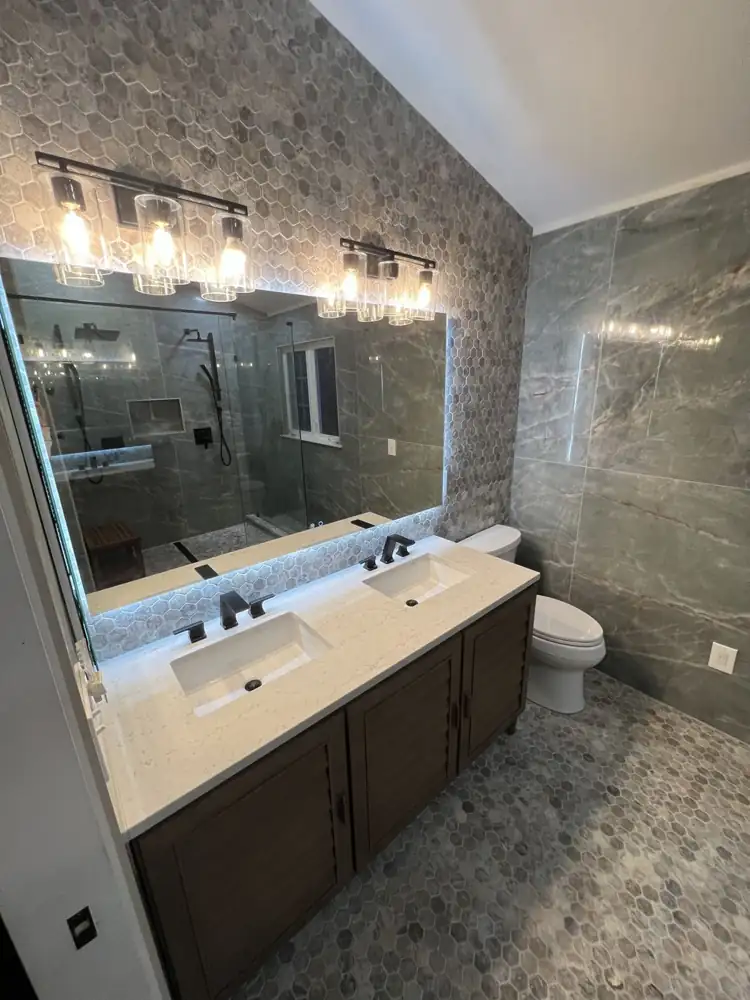 Double vanity with hexagon tile accent wall, backlit mirror and matte black faucets, Northeast Ohio