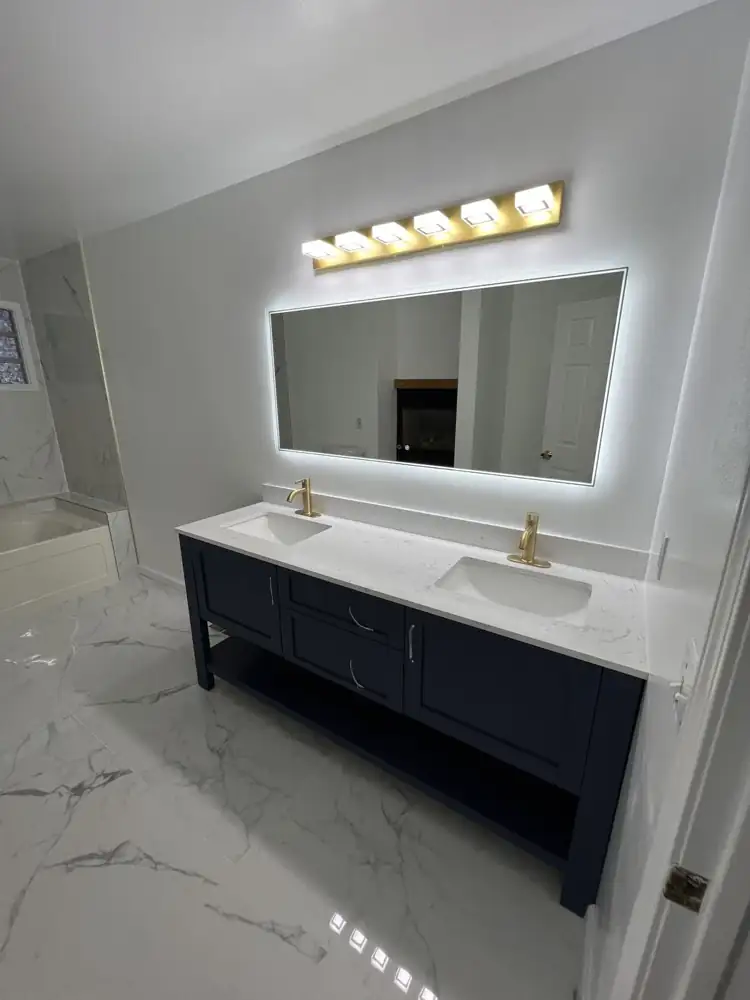 Navy double vanity with quartz top, brushed gold faucets and gold light bar, Northeast Ohio
