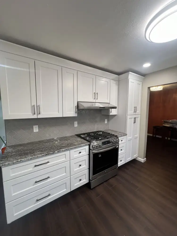 Another view: White shaker cabinets to the ceiling with pantry, granite counters, arabesque tile backsplash and stainless range, Rocky River, Ohio