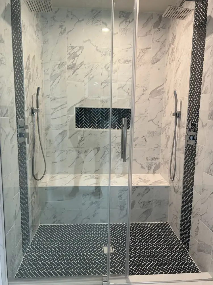 Another view: Double shower with marble-look tile, navy herringbone accents, bench and sliding glass door, Streetsboro, Ohio