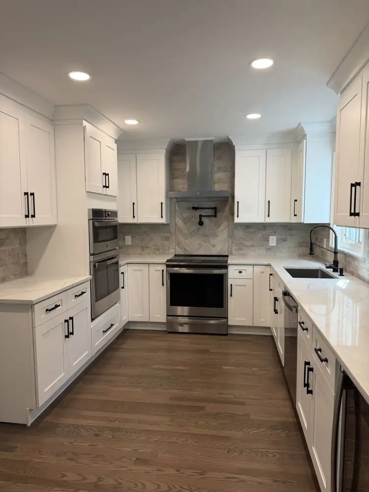 Kitchen remodel with white cabinets, black hardware and brick-look tile