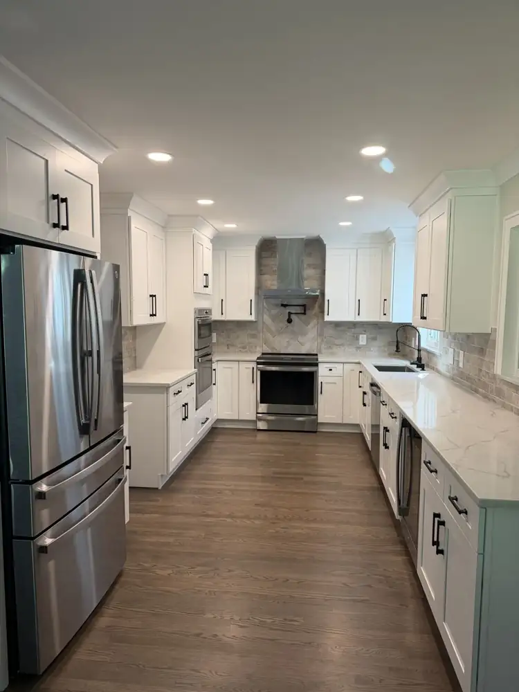 Kitchen remodel in Shaker Heights with white shaker cabinets, quartz countertops and herringbone tile accent, Ohio