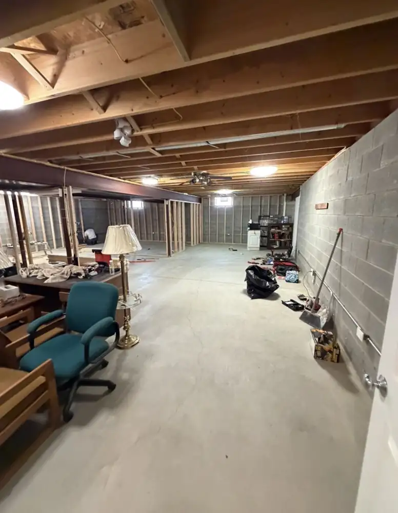 Unfinished basement with exposed joists and block walls before remodel, Solon, Ohio
