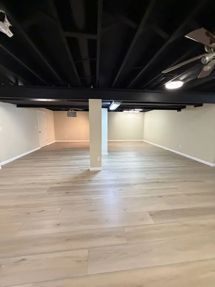 Another view: Finished basement with black painted open ceiling, drywall, wrapped posts and luxury vinyl plank floor, Solon, Ohio