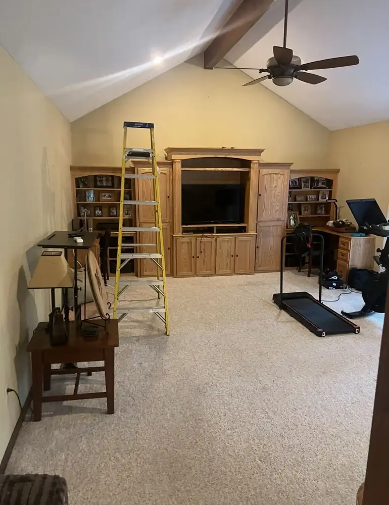 Family room with oak entertainment center, carpet and dated ceiling fan before remodel, Solon, Ohio
