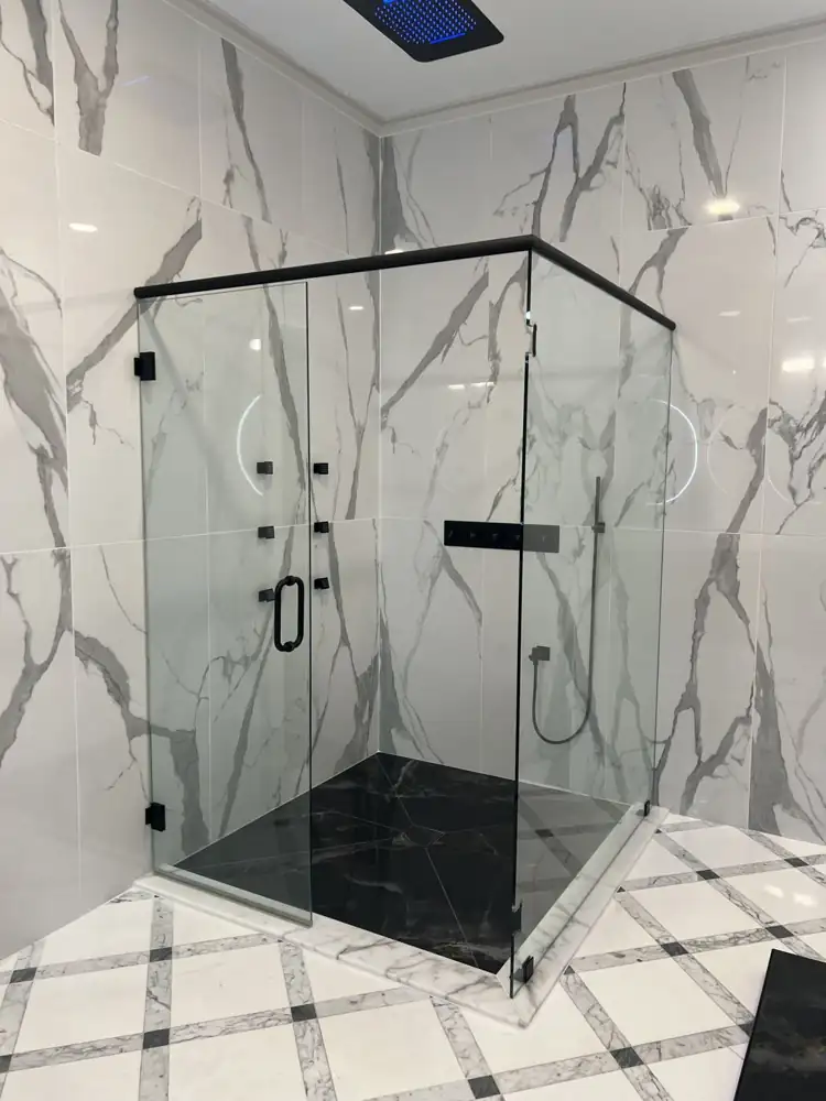 Another view: Primary bathroom with glass shower, LED ceiling rain head, body jets, black marble-look floor and freestanding tub on a lit platform, Strongsville, Ohio