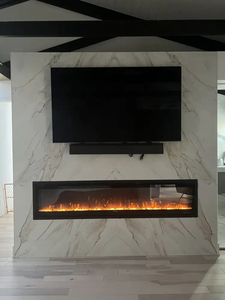Bookmatched marble-look porcelain fireplace wall with linear fireplace and TV