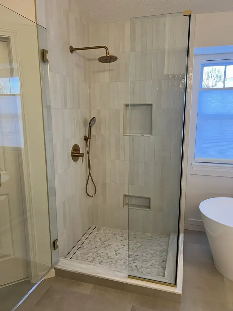 Walk-in shower with glazed vertical stacked tile, gold-trimmed niches, hex mosaic floor and linear drain, Ohio