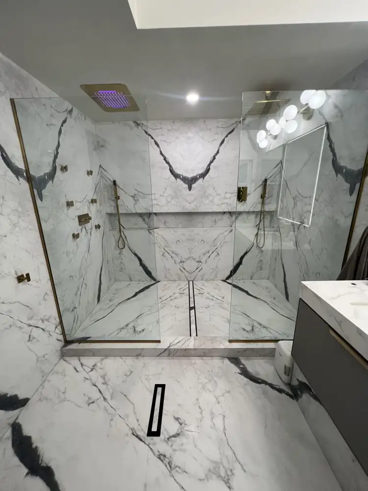 Double walk-in shower with book-matched marble-look porcelain, linear drain and brass body jets, Twinsburg, Ohio