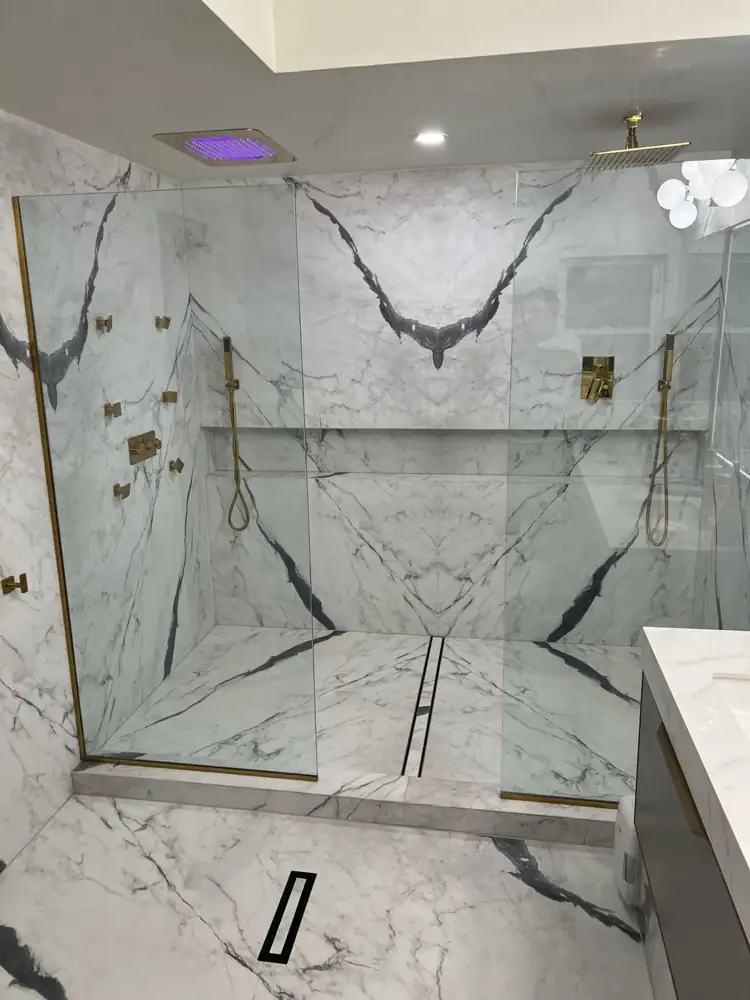 Double walk-in shower with marble-look porcelain after remodel by Lux Home Remodeling, Twinsburg, Ohio