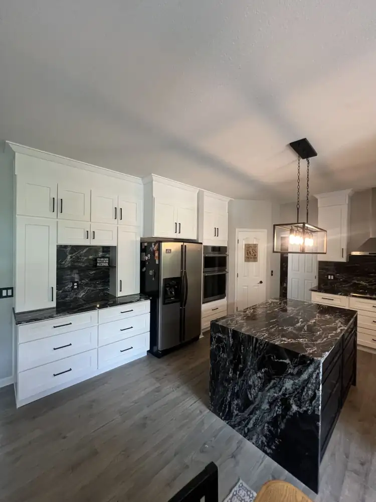 Another view: White shaker kitchen with black granite waterfall island, full-height granite backsplash and stainless hood, Twinsburg, Ohio
