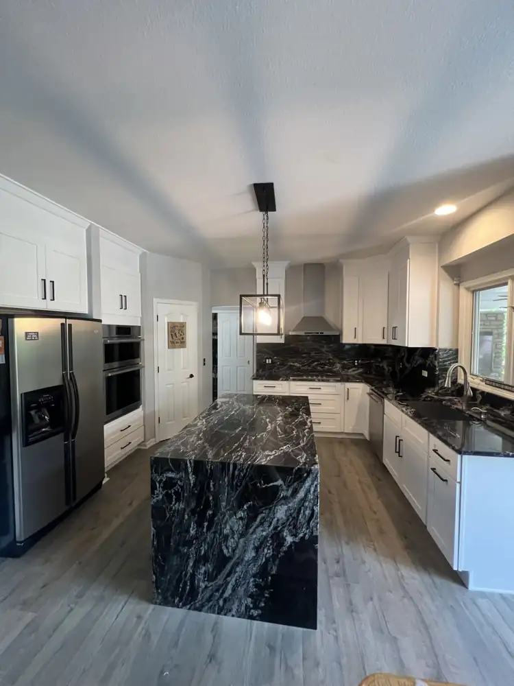 Another view: White shaker kitchen with black granite waterfall island, full-height granite backsplash and stainless hood, Twinsburg, Ohio