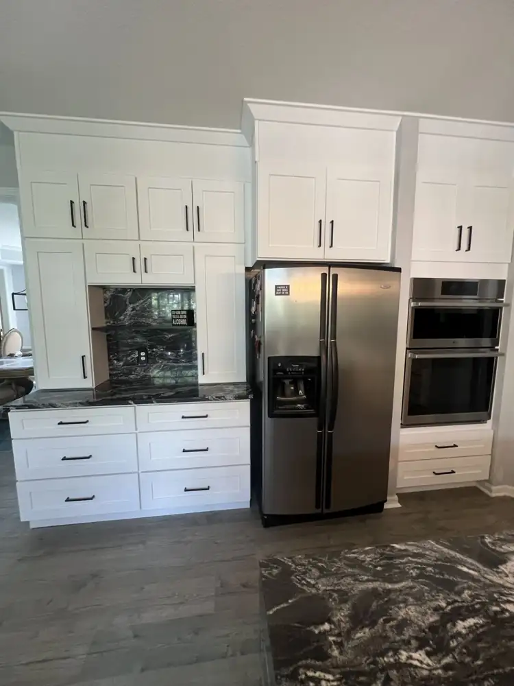 Another view: White shaker kitchen with black granite waterfall island, full-height granite backsplash and stainless hood, Twinsburg, Ohio