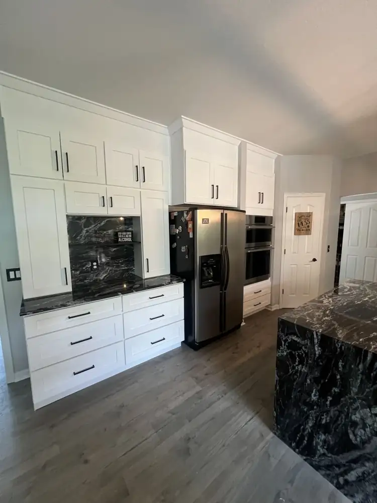 Another view: White shaker kitchen with black granite waterfall island, full-height granite backsplash and stainless hood, Twinsburg, Ohio