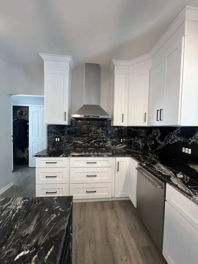 Another view: White shaker kitchen with black granite waterfall island, full-height granite backsplash and stainless hood, Twinsburg, Ohio
