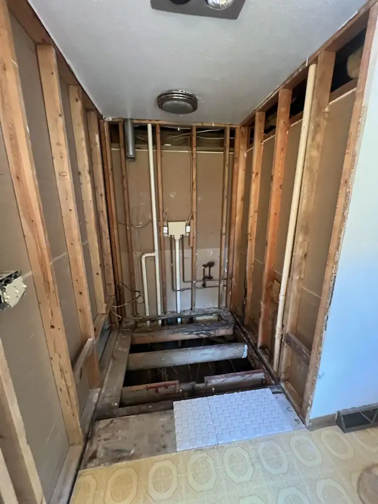 Old shower opened to the studs with damaged subfloor and joists exposed, Westlake, Ohio