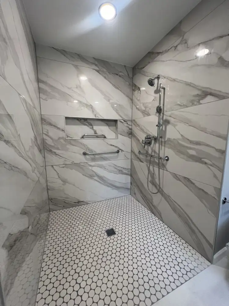 Barrier-free shower with grab bars, long niche and white penny tile floor, Ohio